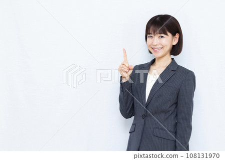 一位30多歲的女商人，穿著西裝，食指向上 108131970