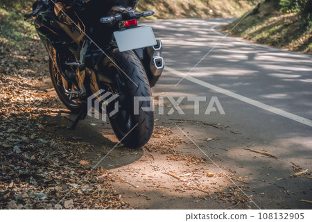 摩托車旅行秋天的陽光透過樹木照射在穿過森林的道路上電影風格 摩托車旅行秋天的陽光透過樹木照射在穿過森林的道路上電影風格 108132905