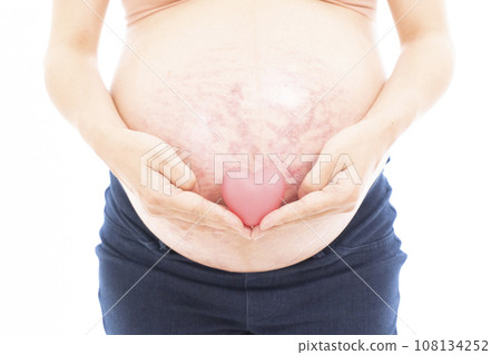 Pregnant woman putting her hand on her stomach with stretch marks and midline 108134252