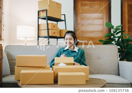 Starting small business entrepreneur of independent Asian female online seller packing products to send to customers and SME delivery concept. Starting small business entrepreneur of independent Asian female online seller packing products to send to customers and SME delivery concept. 108135736