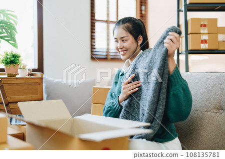 Beautiful Asian woman, blogger, blog, presenting fashion clothes, live video, social media, record her, sell online via digital cameras, sme or small business ecommerce concepts. 108135781