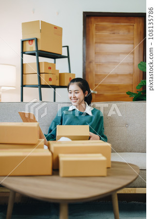 Starting small business entrepreneur of independent Asian female online seller packing products to send to customers and SME delivery concept. Starting small business entrepreneur of independent Asian female online seller packing products to send to customers and SME delivery concept. 108135786