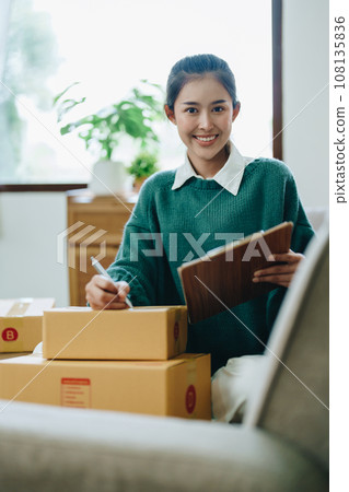 Starting small business entrepreneur of independent Asian female online seller packing products to send to customers and SME delivery concept. 108135836