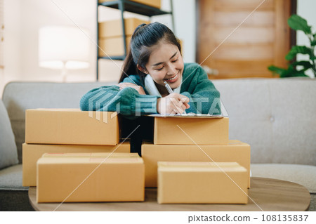 Starting small business entrepreneur of independent Asian female online seller packing products to send to customers and SME delivery concept. 108135837
