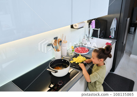 Grandmother and granddaughter are preparing soup. 108135865