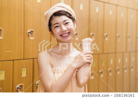 Young woman changing clothes in sauna locker room Young woman changing clothes in sauna locker room 108136161