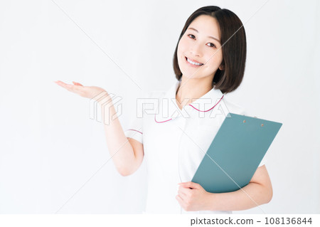 年輕護士一手拿著一份文件，白色背景 108136844