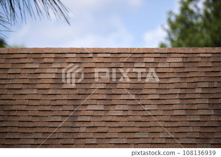 Closeup of house roof top covered with asphalt or bitumen shingles. Waterproofing of new building 108136939