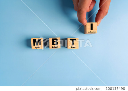 Wooden blocks with the letters MBTI on blue background. Personality typology. Psychology test for human types.MBTI - Myers-Briggs Type Indicator. 108137498