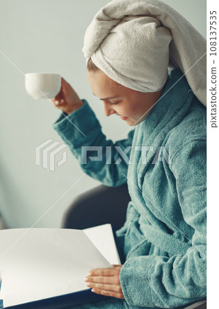 Girl in a studio. Lady in a blue bathrobe. Woman with a documents 108137535