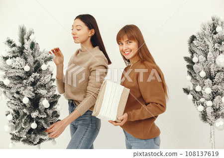Women with presents. Girl in a brown sweater. Ladies in a studio. 108137619