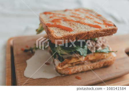 Close up of melting Homemade Tuna Sandwich on wooden cutting plate 108141584