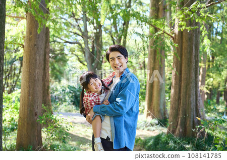 father and daughter playing in the forest 108141785