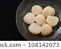 Raw scallops on a black plate 108142073