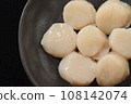 Raw scallops on a black plate 108142074