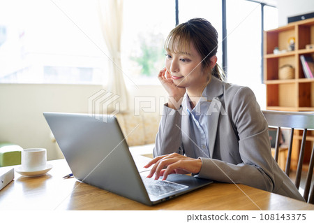An Asian woman operating a computer with a troublesome look An Asian woman operating a computer with a troublesome look 108143375