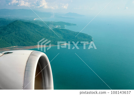 Passenger plane flying over blue ocean Passenger plane flying over blue ocean 108143637