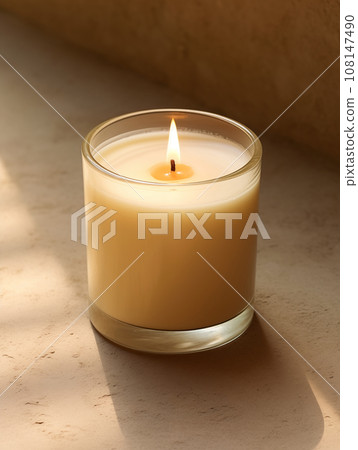 Minimalist burning wax candle in clear glass on natural beige stone background with copy space, styled commercial product mockup Minimalist burning wax candle in clear glass on natural beige stone background with copy space, styled commercial product mockup 108147490