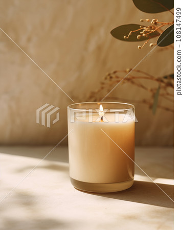 Minimalist burning wax candle in clear glass on natural beige stone background with copy space, styled commercial product mockup Minimalist burning wax candle in clear glass on natural beige stone background with copy space, styled commercial product mockup 108147499
