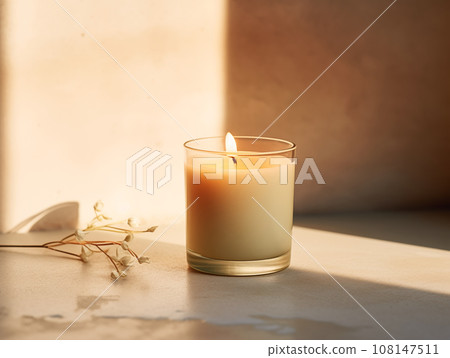 Minimalist burning wax candle in clear glass on natural beige stone background with copy space, styled commercial product mockup Minimalist burning wax candle in clear glass on natural beige stone background with copy space, styled commercial product mockup 108147511