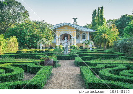 House and green buxus labyrinths in summer ornamental garden. House and green buxus labyrinths in summer ornamental garden. 108148155