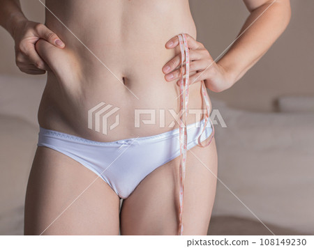 woman with belly fat measuring her waist. woman shows her fat woman with belly fat measuring her waist. woman shows her fat 108149230