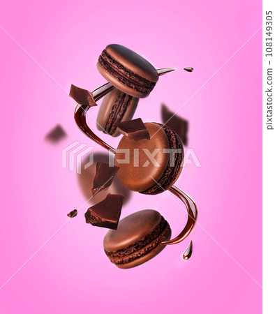 levitating chocolate French Macarons with pieces of chocolate and chocolate syrup pink background levitating chocolate French Macarons with pieces of chocolate and chocolate syrup pink background 108149305