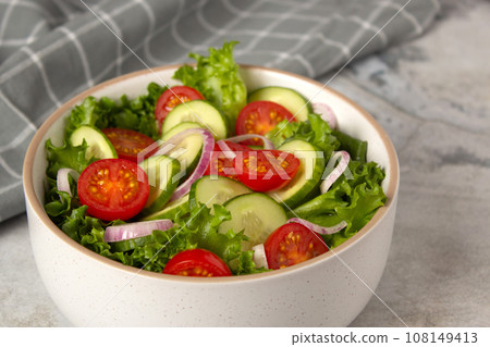 Vegetable salad with cucumber, tomato, onion, green salad and linseed seeds. Close up photo of healthy food Vegetable salad with cucumber, tomato, onion, green salad and linseed seeds. Close up photo of healthy food 108149413