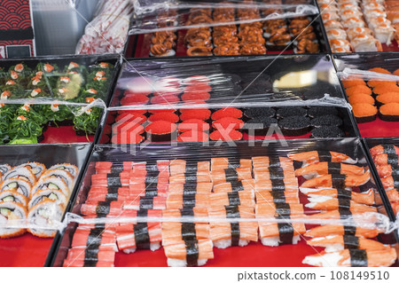 Various sushi on street market. Sushi with black and red caviar, red salmon, shrimps, mussels and Hiyashi Wakame seaweed salad 108149510