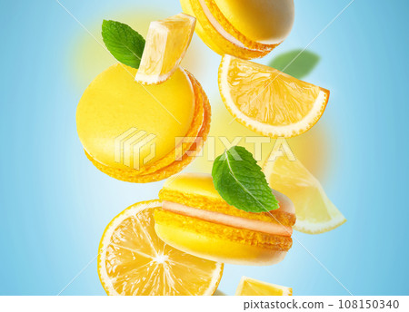 Lemon yellow macaroons are flying on a blue background with mint closeup 108150340