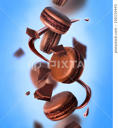 French strawberry macarons with berries on the air. Concept of levitation. Blue background. French strawberry macarons with berries on the air. Concept of levitation. Blue background. 108150443