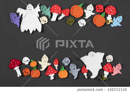 Happy Halloween holiday concept. Halloween decorations, knitted ghosts, red toadstools, orange pumpkins on black background. Halloween greeting card mockup with copy space. Flat lay, top view 108151526