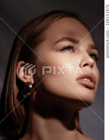 A lovely model with gold rings, earrings, and a 108151878