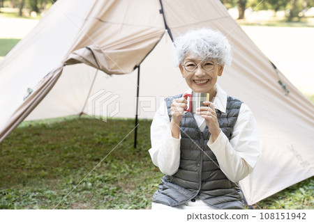 A woman smiling with a tent in the background A woman smiling with a tent in the background 108151942
