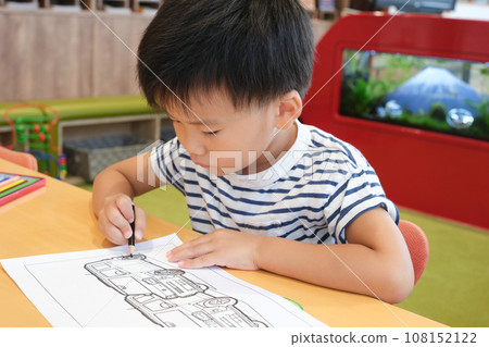 boy playing with coloring book boy playing with coloring book 108152122