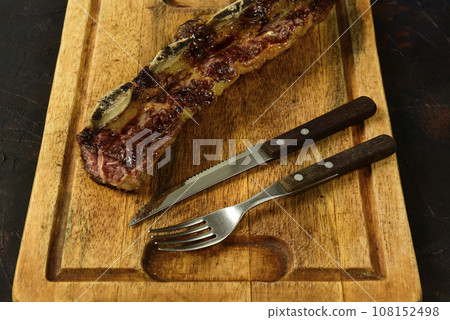 Roasted beef ribs presented on the table, traditional Argentine cuisine, Asado barbecue, Patagonia, Argentina. 108152498