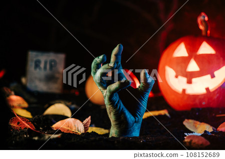 Terrible zombie hand climbs out grave. Creepy moment from undead life. Halloween 108152689