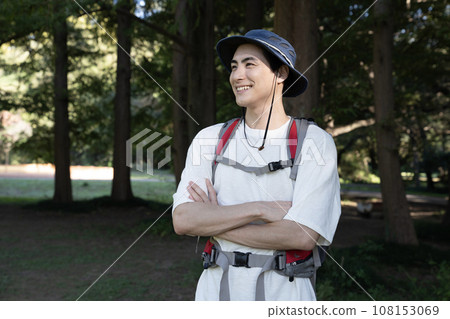 A man walking with a mountain climbing bag A man walking with a mountain climbing bag 108153069
