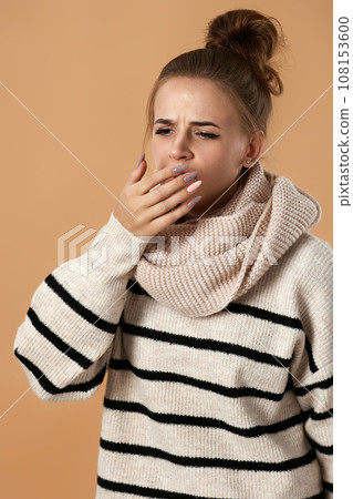 sick woman in sweater coughing covering mouth with hand 108153600