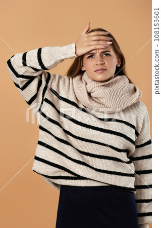 Young woman in wool sweater suffering from headache 108153601