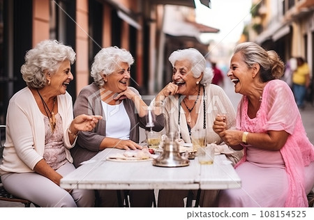 Five stylishly dressed Italian women in their 80s enjoy a refreshing lemonade at a street cafe while engaging in lively conversation Five stylishly dressed Italian women in their 80s enjoy a refreshing lemonade at a street cafe while engaging in lively conversation 108154525