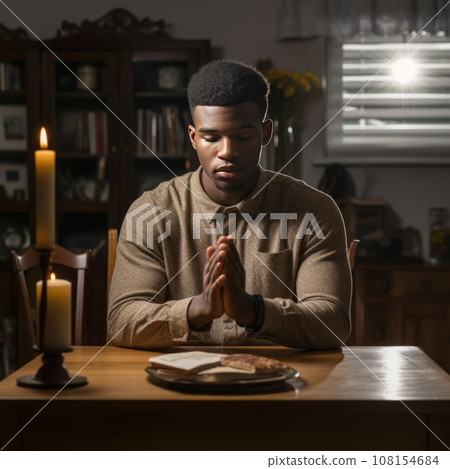 Young man praying at home, hands folded Young man praying at home, hands folded 108154684