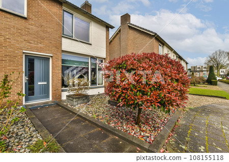 an outside view of a house with red leaves on the ground and blue sky in the background - stock photo an outside view of a house with red leaves on the ground and blue sky in the background - stock photo 108155118