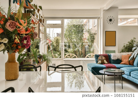 a living room with blue couches and colorful flowers in vases on the coffee table next to the sofa 108155151