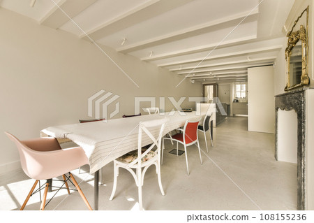 a dining room with chairs and a fire place in the middle of the room that is being used for cooking a dining room with chairs and a fire place in the middle of the room that is being used for cooking 108155236