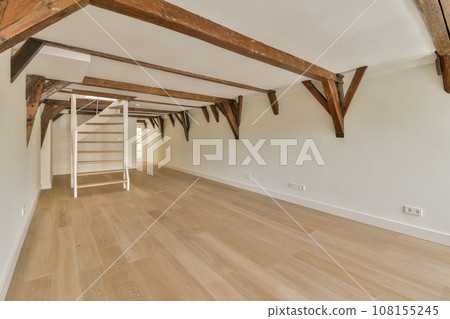 an empty room with wood flooring and exposed beams on the ceiling above it is a staircase leading up to the second floor 108155245
