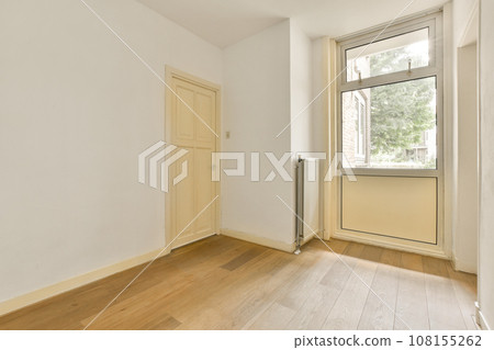an empty room with wood floors and white walls, there is a large window in the wall to the right an empty room with wood floors and white walls, there is a large window in the wall to the right 108155262