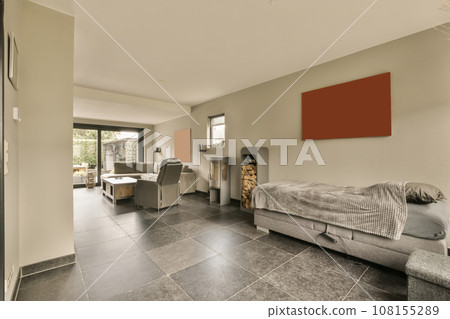 a living room with tile flooring and gray couches in front of sliding glass door that leads to patio 108155289