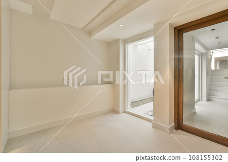 an empty room with a mirror on the wall and door to another room in the same area, as well an empty room with a mirror on the wall and door to another room in the same area, as well 108155302