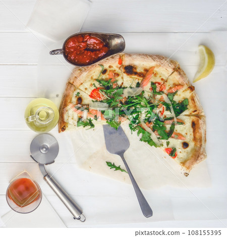 Part of pizza on white wood table Part of pizza on white wood table 108155395
